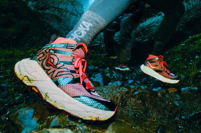 Gros plan d’une personne mettant les pieds dans l’eau rocheuse en portant des chaussures HOKA.